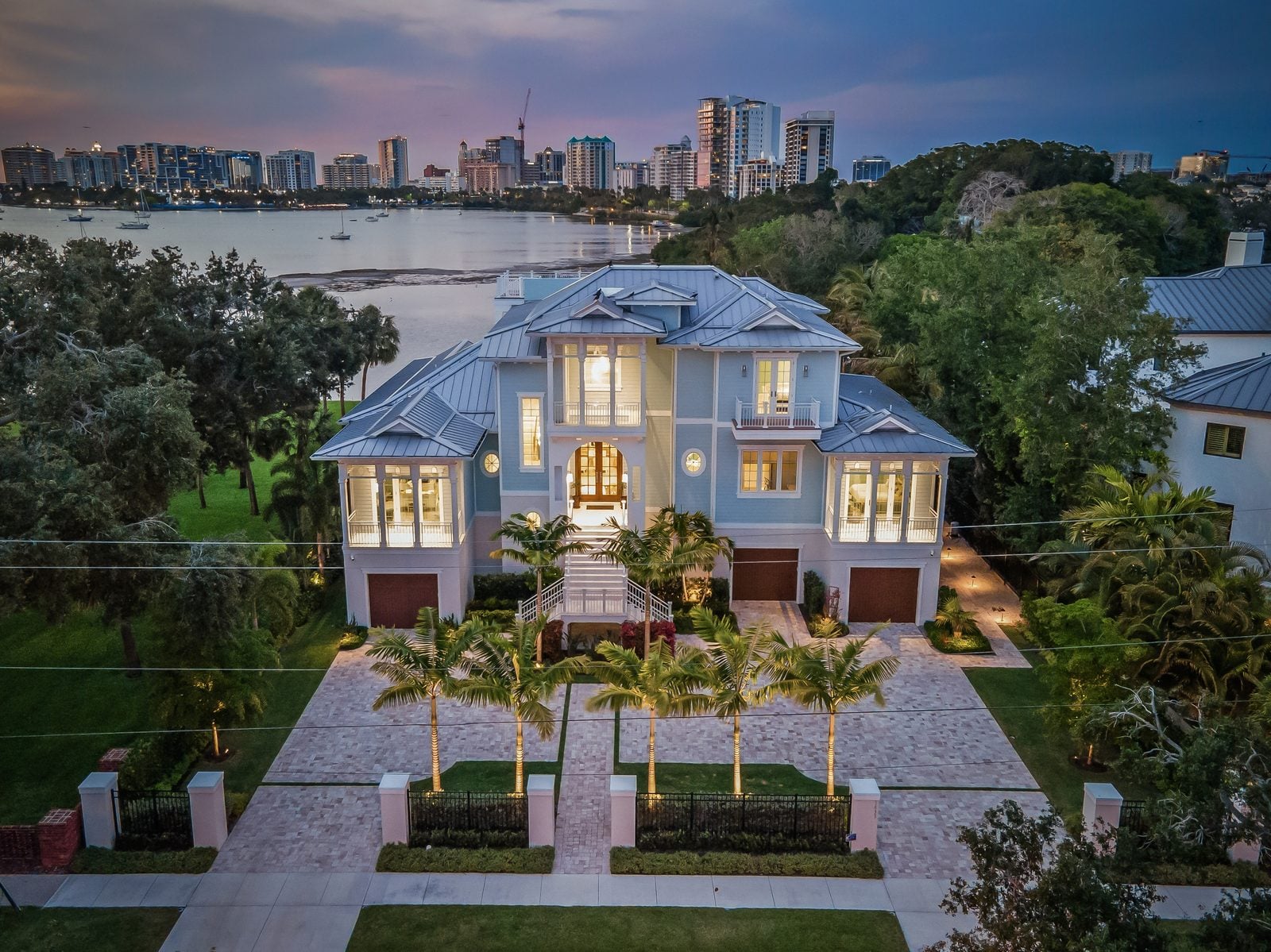 Bayfront Blues: front elevation at dusk, lit from within, with the bayfront skyline beyond